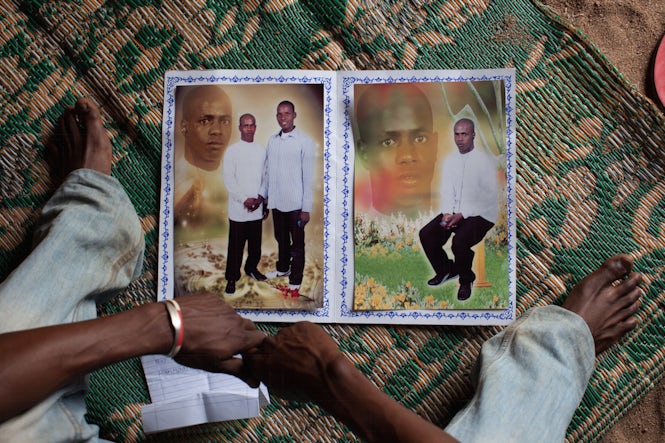 Un migrante senegalés muestra una foto de sí mismo que trajo de Senegal. Muchos desean volver por razones personales. (REUTERS/Joe Penney)